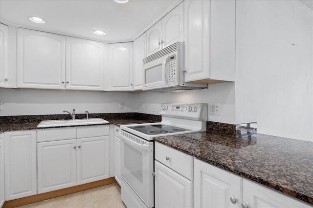 kitchen featuring white appliances, white cabinetry, dark stone counters, and sink