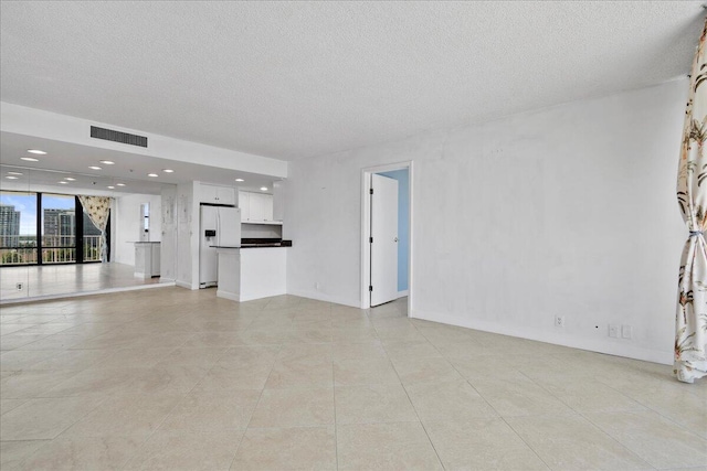 unfurnished living room with light tile patterned floors and a textured ceiling