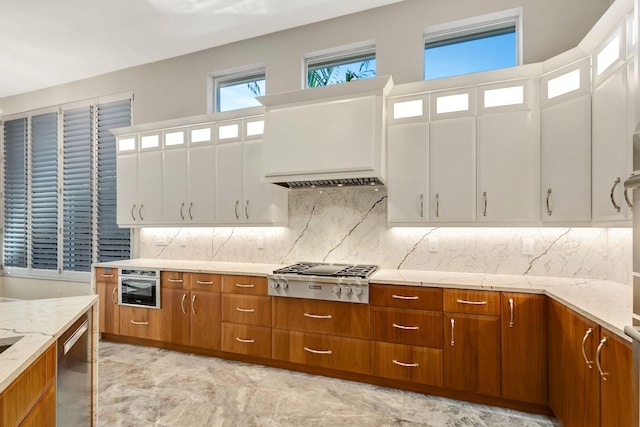 kitchen featuring decorative backsplash, white cabinetry, and appliances with stainless steel finishes