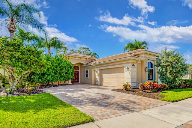 mediterranean / spanish home with a garage and a front lawn