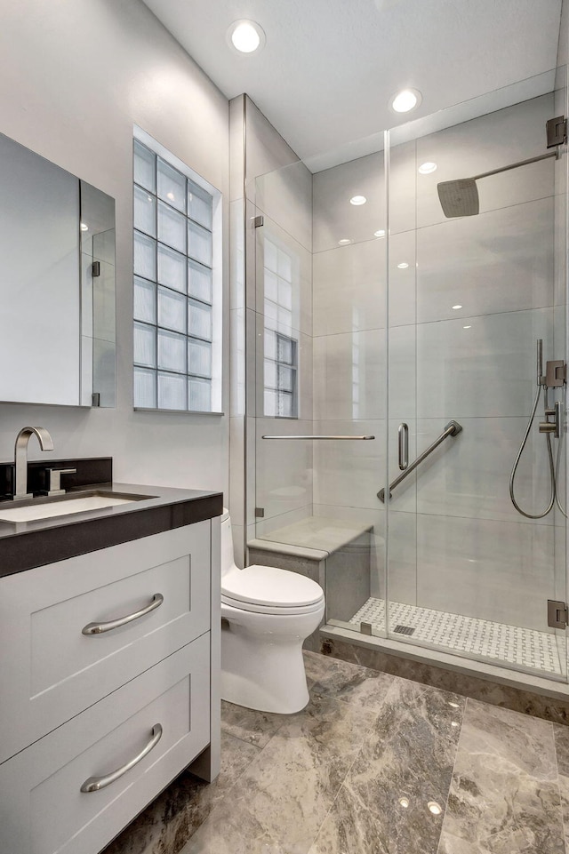 bathroom featuring vanity, toilet, and walk in shower