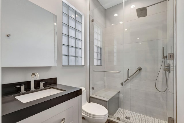 bathroom with vanity, toilet, and a shower with shower door