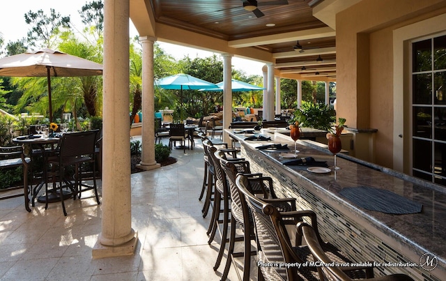 view of patio / terrace featuring a bar and ceiling fan