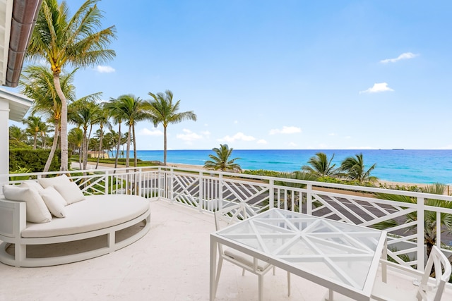 view of patio featuring a water view and a beach view