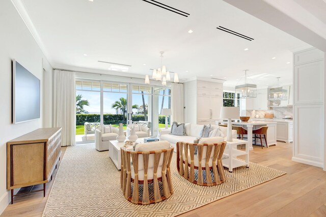 dining area featuring a chandelier, light wood-style floors, recessed lighting, and french doors