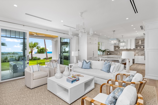 living room with light hardwood / wood-style floors and a notable chandelier