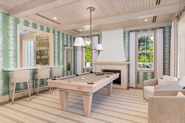 kitchen with white cabinetry, decorative light fixtures, plenty of natural light, and a kitchen island with sink