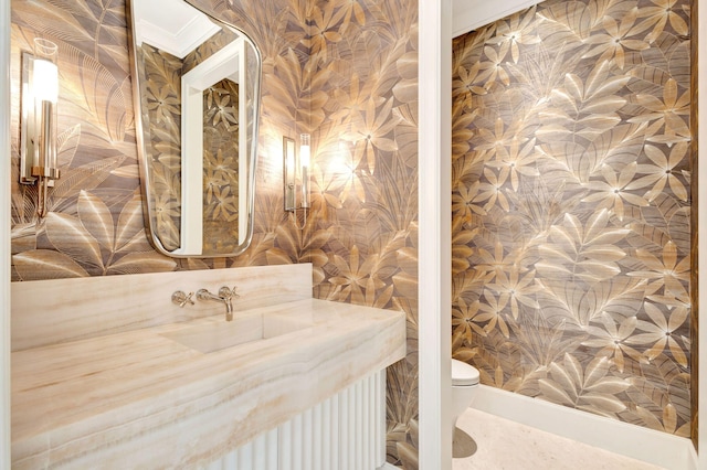 bathroom with toilet, wallpapered walls, and crown molding