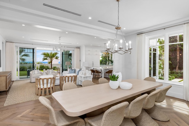 dining space featuring light parquet floors, a notable chandelier, and ornamental molding