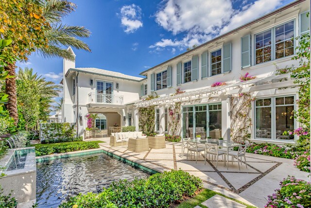 back of property featuring a pergola, an outdoor living space, stucco siding, an outdoor pool, and a patio