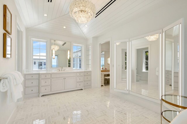 full bath featuring a chandelier, vaulted ceiling, wood ceiling, toilet, and vanity