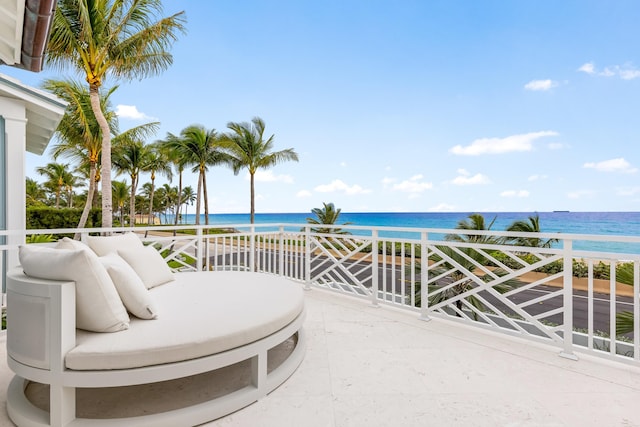 view of patio featuring a water view, a view of the beach, and a balcony