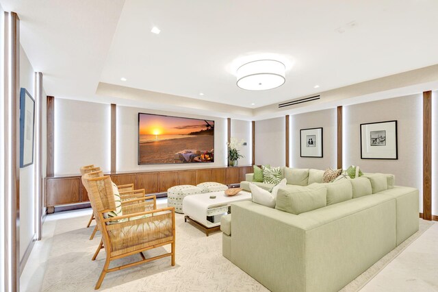 living room with a tray ceiling and light colored carpet