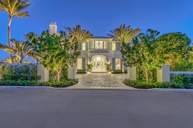 view of front of home with stucco siding, solar panels, driveway, and french doors