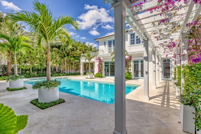 swimming pool featuring a pergola, french doors, and a patio area