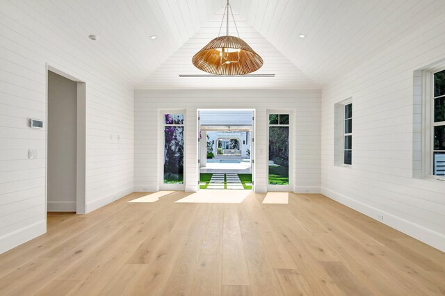 entrance foyer with wooden ceiling, light wood-style floors, baseboards, and wooden walls