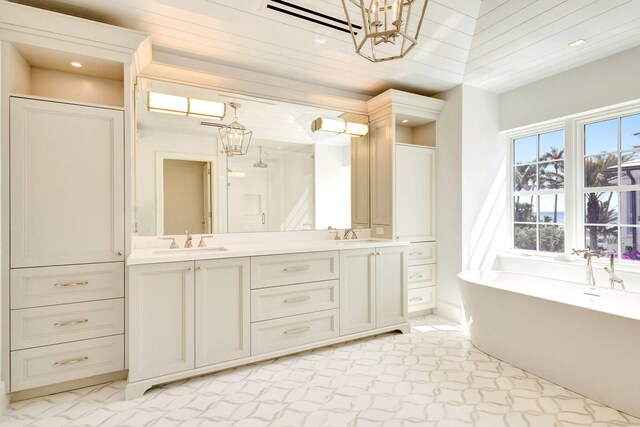 bathroom featuring a chandelier, double vanity, a soaking tub, a shower, and recessed lighting