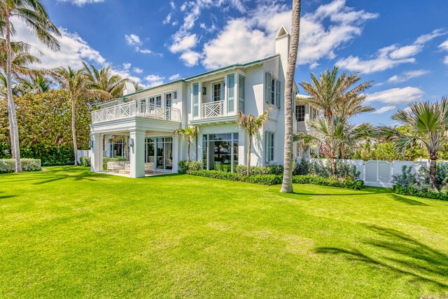 back of property with a balcony, a patio area, and stucco siding