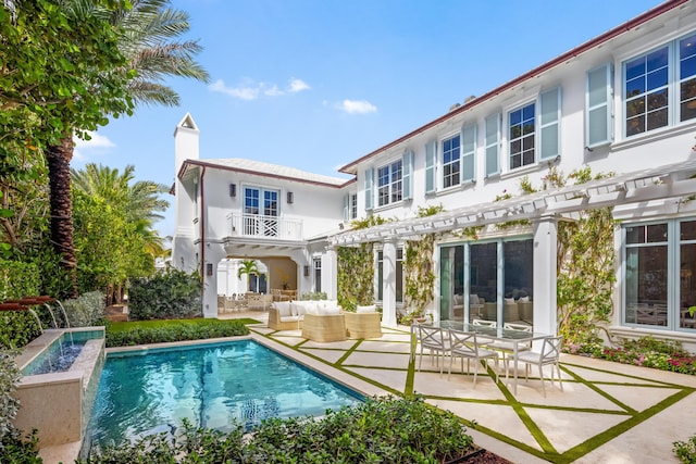 back of property with a patio, an outdoor living space, and a balcony