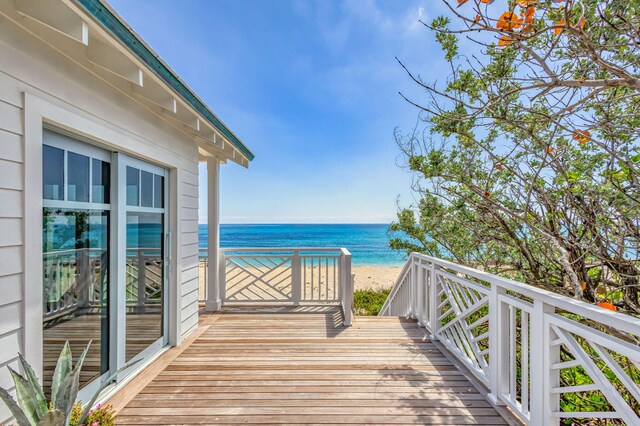wooden terrace with view of water and beach