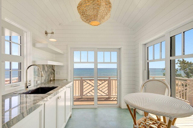 rear view of property with a balcony, a patio area, an outdoor pool, and a pergola