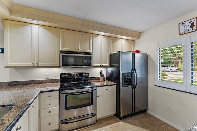 kitchen featuring stainless steel appliances and dark stone counters