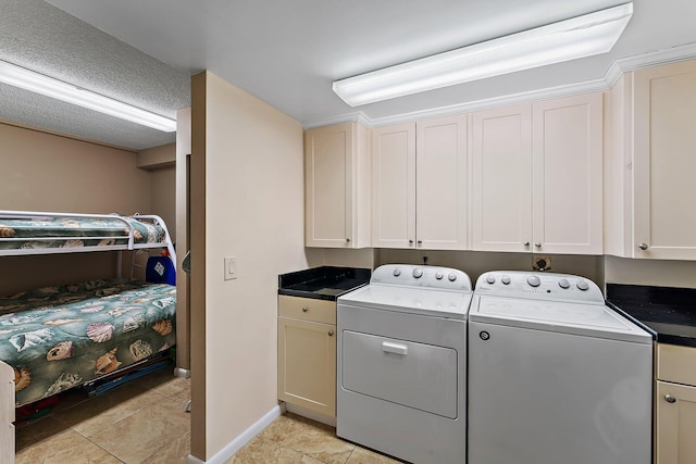 washroom featuring washer and dryer, light tile patterned floors, and cabinets