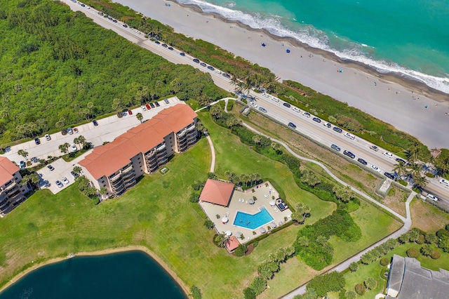 birds eye view of property with a water view and a view of the beach