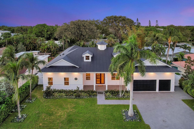 view of front of home featuring a garage and a lawn