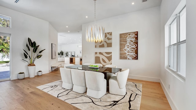 dining room featuring light hardwood / wood-style floors and a high ceiling