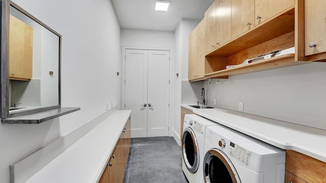 clothes washing area featuring cabinets, independent washer and dryer, and sink