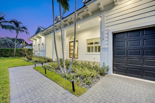 exterior entry at dusk with a garage