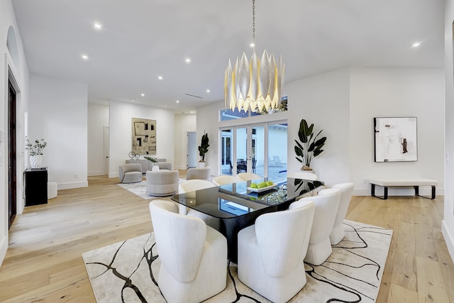 dining area featuring french doors, a notable chandelier, and light wood-type flooring