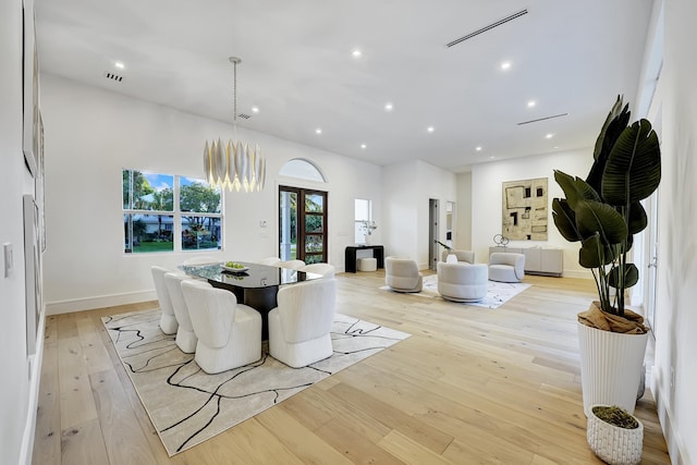 dining area featuring light hardwood / wood-style floors and a notable chandelier