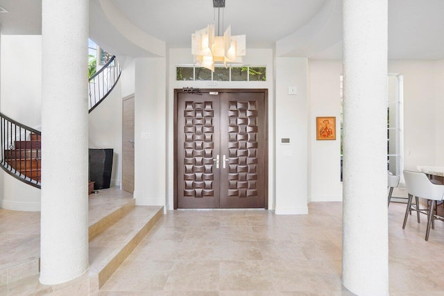 tiled foyer with an inviting chandelier