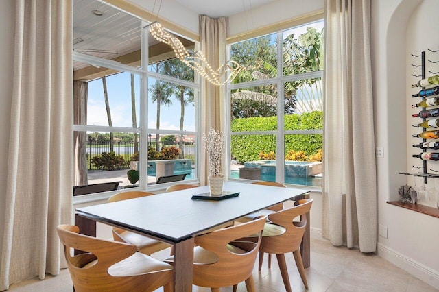 tiled dining room with a notable chandelier