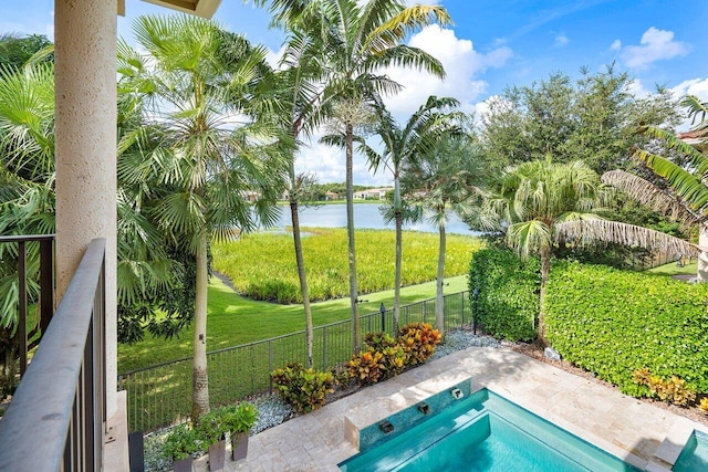 view of pool with a yard and a water view