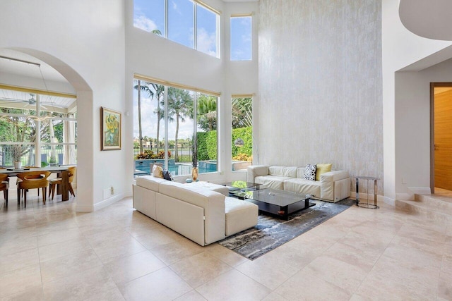 living room with light tile patterned floors, a high ceiling, and plenty of natural light