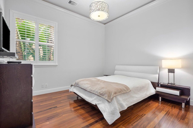 bedroom with crown molding and dark wood-type flooring