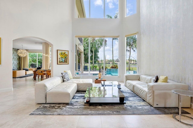 living room with a wealth of natural light, a high ceiling, and a notable chandelier