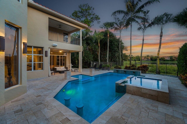 pool at dusk featuring a patio area, an outdoor living space, an in ground hot tub, and ceiling fan