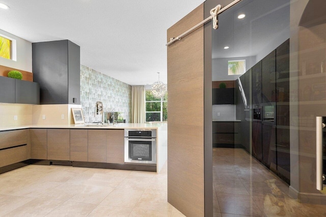 kitchen with sink, plenty of natural light, and stainless steel oven