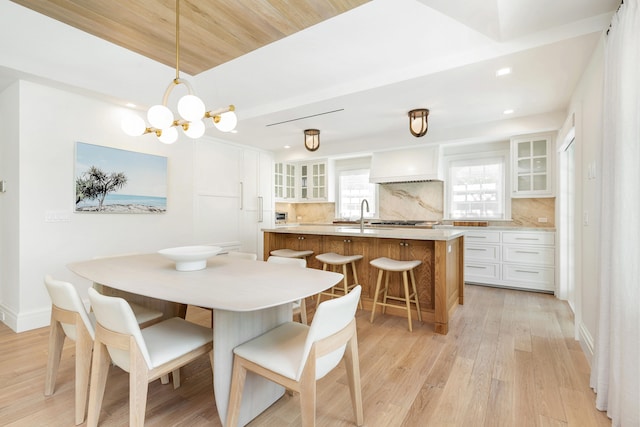 dining space featuring light hardwood / wood-style floors, a chandelier, and sink