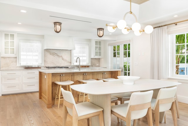 kitchen featuring a center island, white cabinets, light hardwood / wood-style flooring, and tasteful backsplash