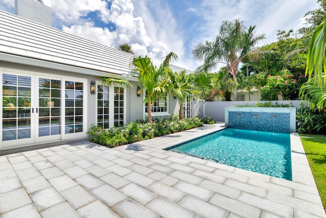 view of pool with french doors and a patio area