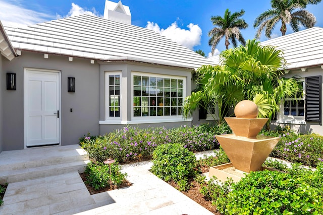 284 Monterey Rd, Palm Beach, FL 33480 - property entrance with stucco siding and a chimney