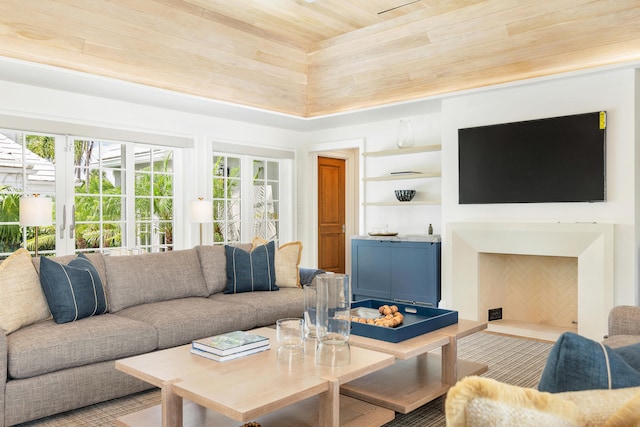 living room with wood ceiling, built in shelves, and a towering ceiling