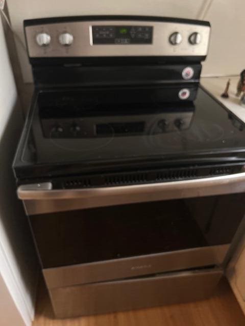 room details featuring electric range and wood-type flooring