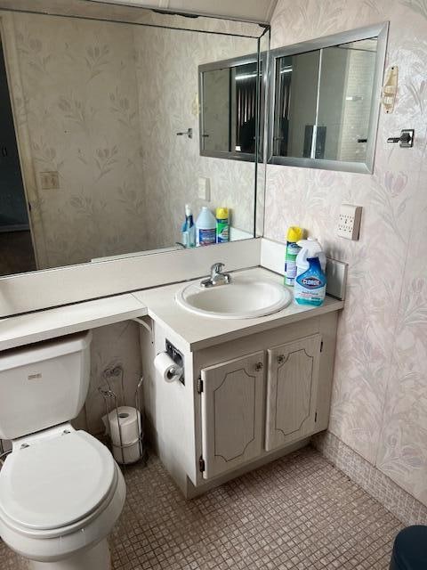 bathroom featuring vanity, toilet, and tile patterned flooring