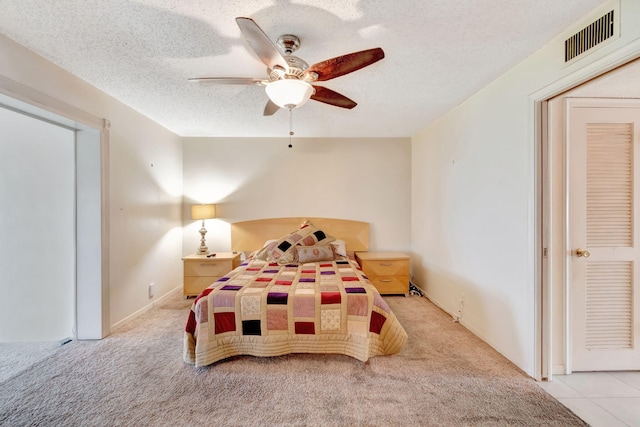 carpeted bedroom with ceiling fan and a textured ceiling